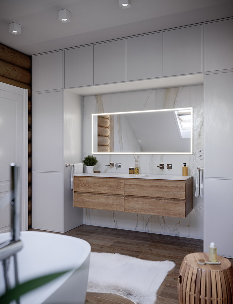 Photo of a large contemporary master bathroom in Valencia with flat-panel cabinets, white cabinets, a freestanding tub, white tile, porcelain tile, white walls, solid surface benchtops, white benchtops, medium hardwood floors, an integrated sink and brown floor.