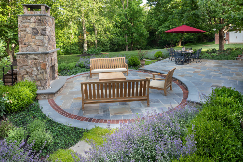 Photo of a medium sized classic back patio in DC Metro with a fireplace and natural stone paving.