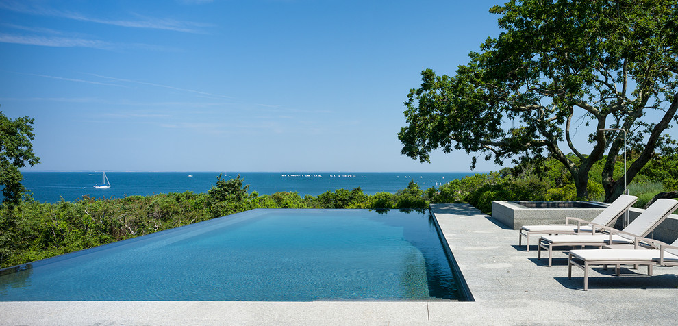Inspiration for a transitional hillside stone infinity pool remodel in Boston