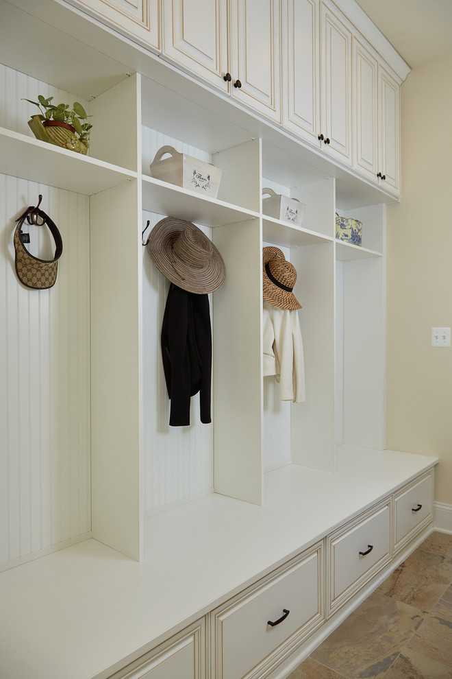 Inspiration for a large traditional mudroom in DC Metro with beige walls and travertine floors.