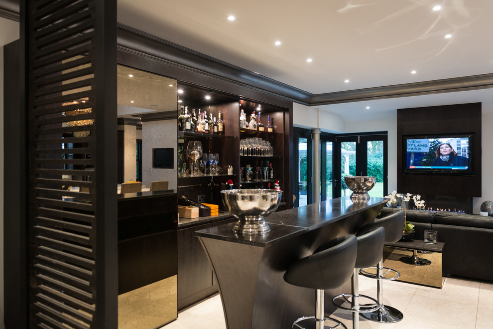Design ideas for a large contemporary galley seated home bar in Manchester with flat-panel cabinets, dark wood cabinets, granite benchtops, porcelain floors and mirror splashback.