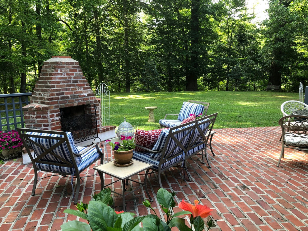 Photo of a large country backyard patio in Philadelphia with with fireplace, brick pavers and a pergola.