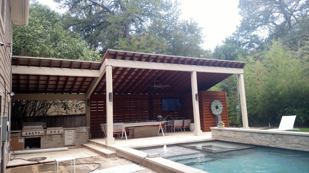 This is an example of a large contemporary backyard verandah in Austin with a pergola.