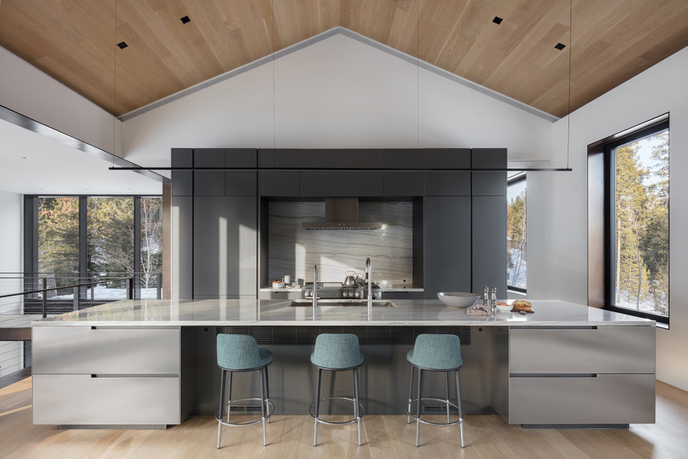 Idées déco pour une cuisine américaine montagne avec un placard à porte plane, parquet clair, îlot et un plafond en bois.