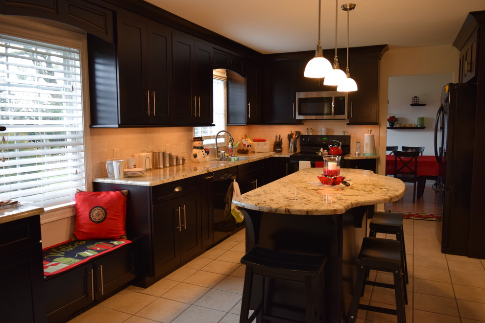 Example of a transitional u-shaped ceramic tile kitchen design with an undermount sink, shaker cabinets, dark wood cabinets, quartz countertops, beige backsplash, subway tile backsplash, black appliances and an island