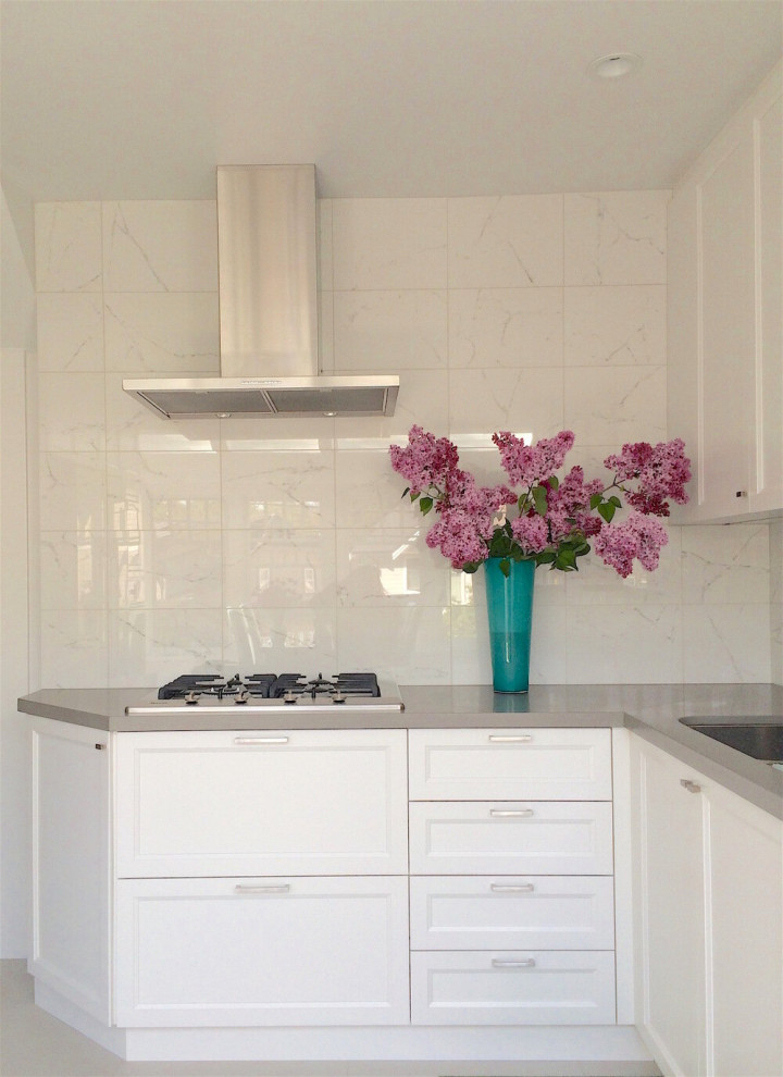 Enclosed kitchen - mid-sized transitional l-shaped enclosed kitchen idea with recessed-panel cabinets, white cabinets, quartz countertops, white backsplash, stone tile backsplash, no island and gray countertops