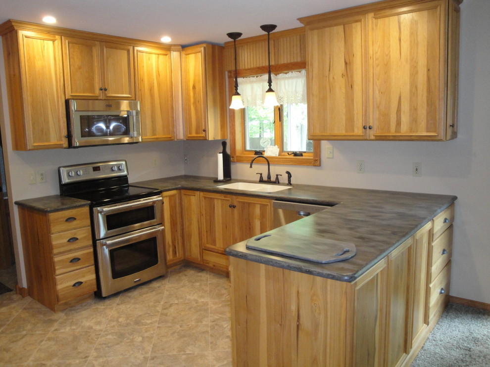 Mid-sized transitional u-shaped vinyl floor and beige floor eat-in kitchen photo with an undermount sink, flat-panel cabinets, light wood cabinets, solid surface countertops, stainless steel appliances, no island and brown countertops