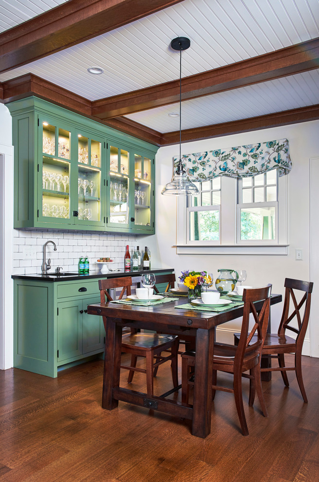 Inspiration for a large traditional single-wall eat-in kitchen in New York with shaker cabinets, green cabinets, granite benchtops, white splashback, ceramic splashback, stainless steel appliances, medium hardwood floors, beige floor, black benchtop and an undermount sink.