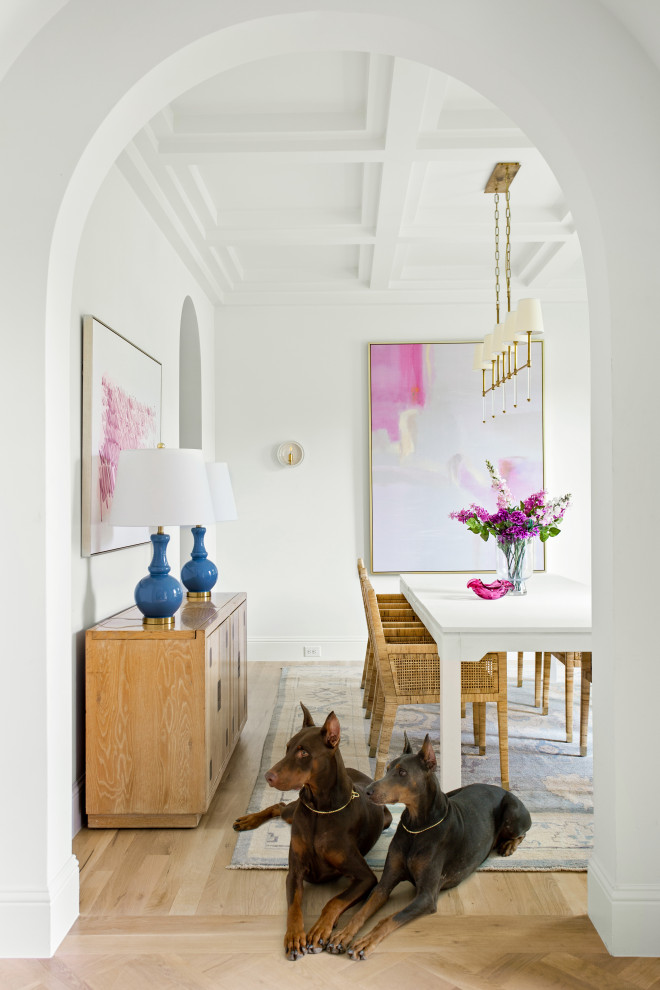 На фото: большая кухня-столовая в стиле неоклассика (современная классика) с белыми стенами, светлым паркетным полом, коричневым полом и кессонным потолком