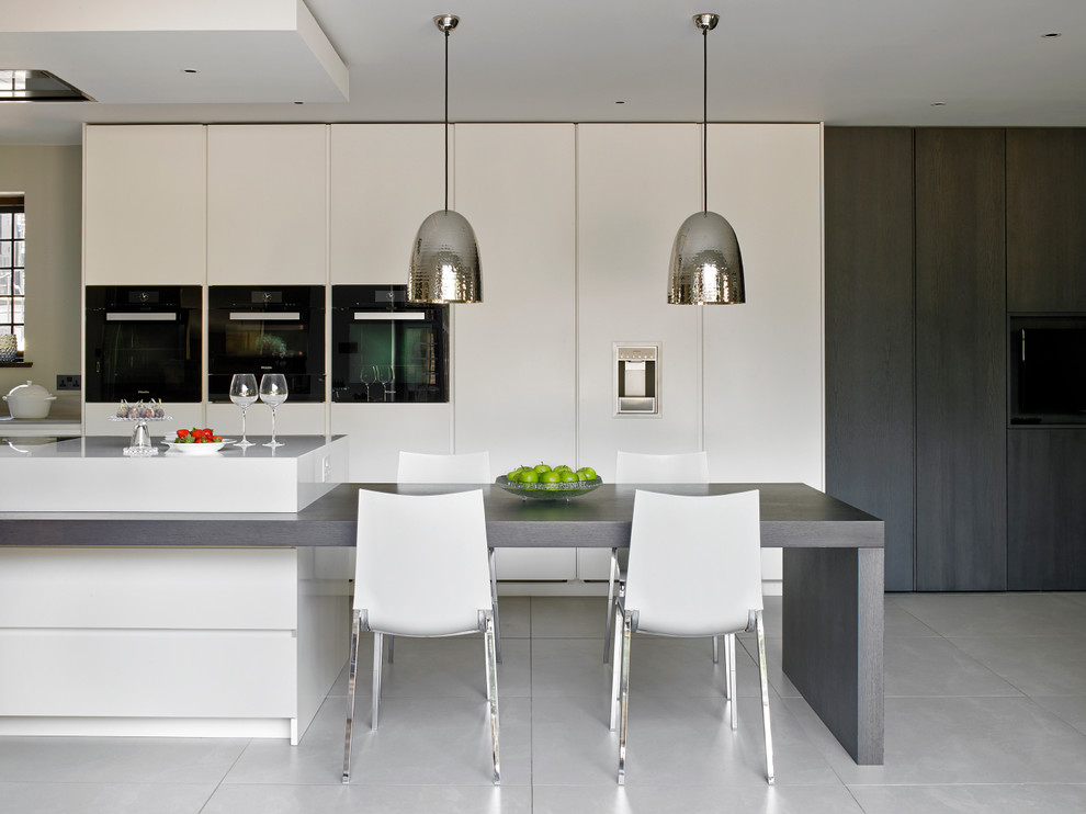 Inspiration for a contemporary kitchen in London with flat-panel cabinets, white cabinets, porcelain floors and with island.