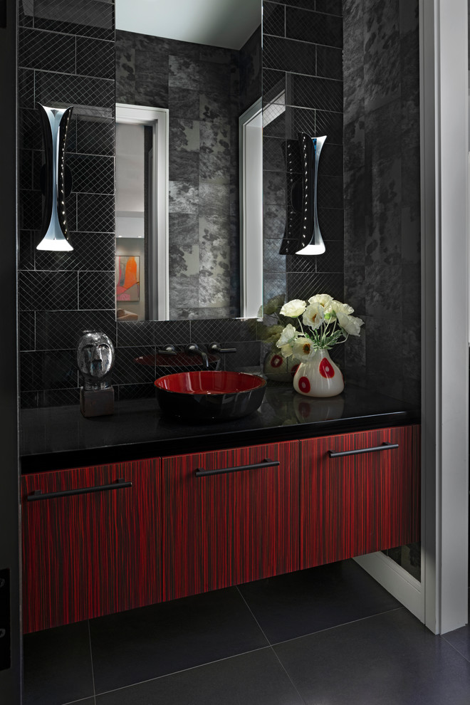 Design ideas for a contemporary powder room in Detroit with flat-panel cabinets, red cabinets, a vessel sink, black floor, black tile, black walls and black benchtops.