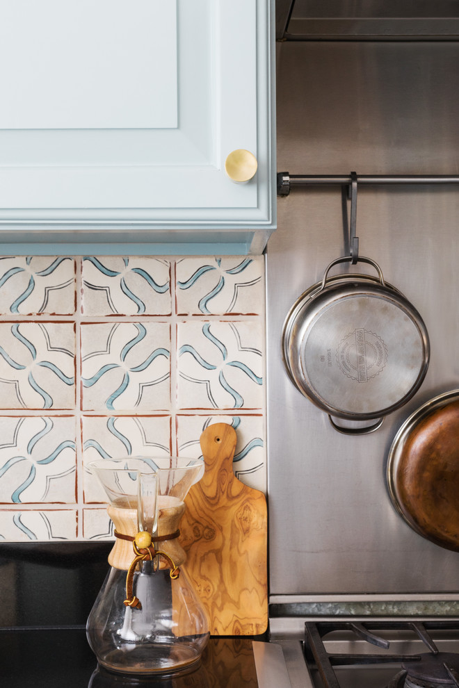 Mid-sized elegant l-shaped medium tone wood floor and brown floor eat-in kitchen photo in Boston with blue cabinets, terra-cotta backsplash, an undermount sink, raised-panel cabinets, quartz countertops, multicolored backsplash, stainless steel appliances and an island