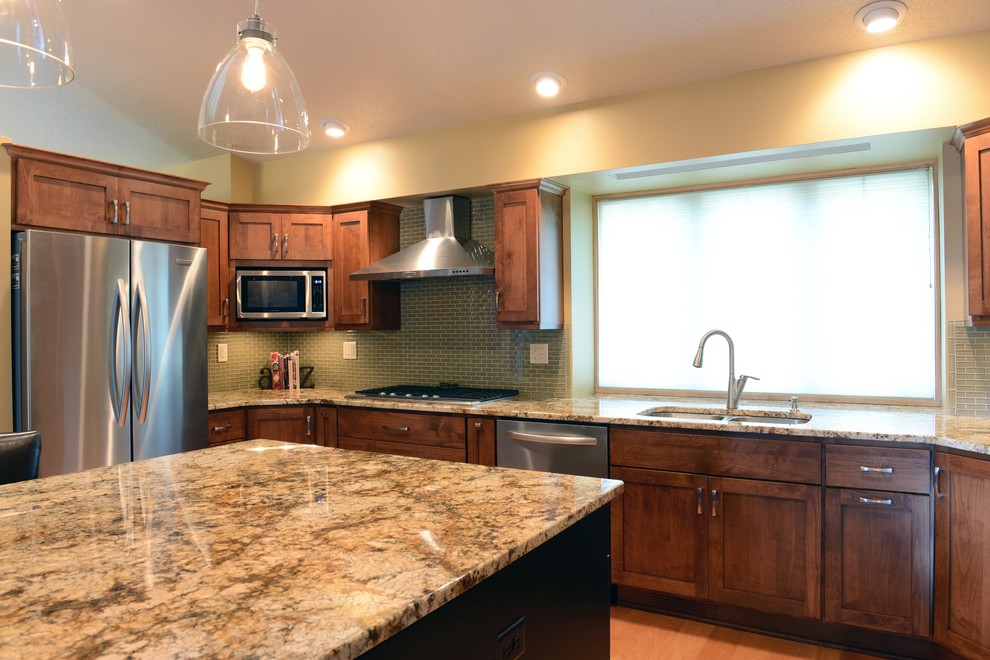 Open concept kitchen - mid-sized transitional u-shaped light wood floor open concept kitchen idea with an undermount sink, shaker cabinets, medium tone wood cabinets, granite countertops, glass tile backsplash, stainless steel appliances and an island