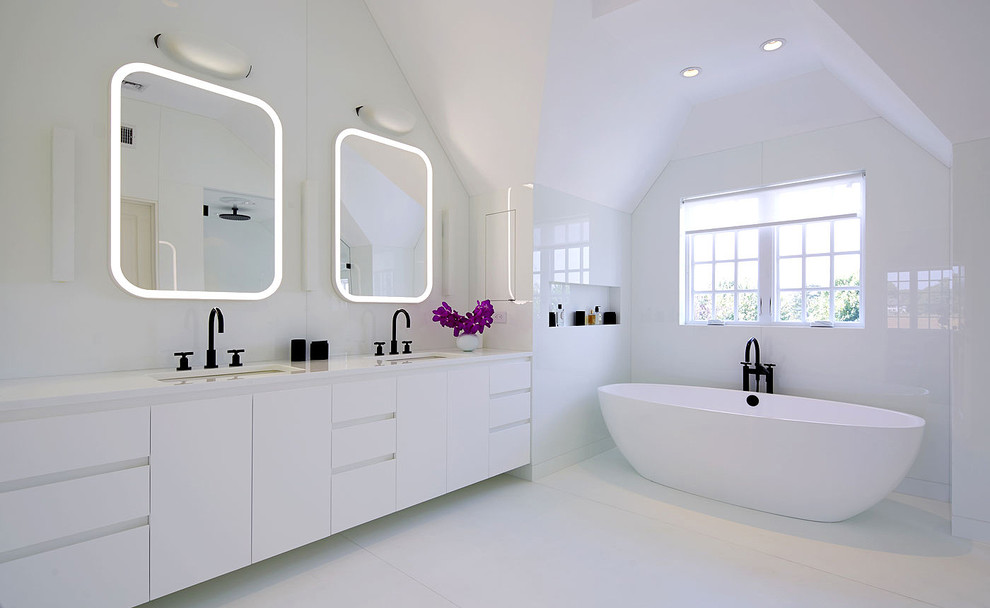 Inspiration for a contemporary master bathroom in New York with flat-panel cabinets, white cabinets, a freestanding tub, an alcove shower, white walls and an undermount sink.