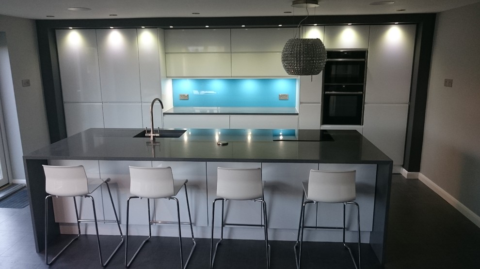 Inspiration for a large contemporary single-wall eat-in kitchen in Other with an undermount sink, flat-panel cabinets, white cabinets, quartzite benchtops, blue splashback, black appliances, vinyl floors and with island.
