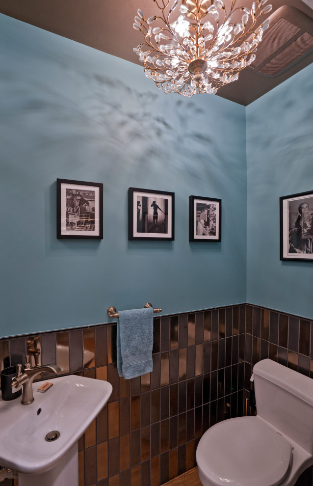 Inspiration för ett litet 50 tals toalett, med en toalettstol med hel cisternkåpa, svart kakel, porslinskakel, blå väggar, ljust trägolv, ett piedestal handfat och brunt golv