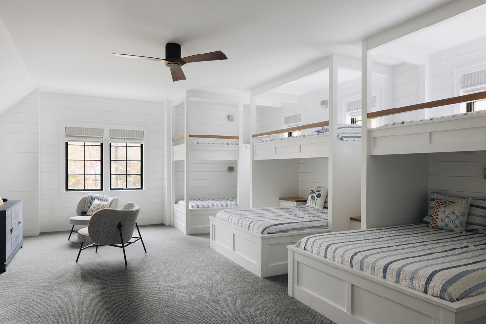 Girls' Bunk Room - Girls' room featuring custom built-in bunk beds that sleep eight, striped bedding, wood accents, gray carpet, black windows, gray chairs, and shiplap walls,