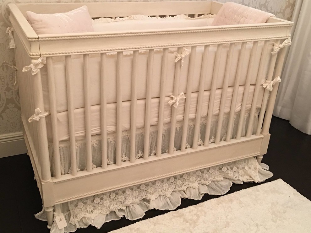 Design ideas for a mid-sized traditional nursery for girls in New York with beige walls and dark hardwood floors.