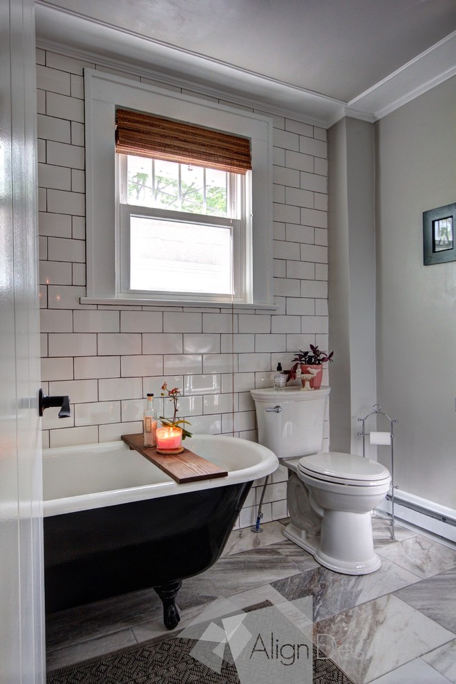 Photo of a small eclectic 3/4 bathroom in Other with black cabinets, a claw-foot tub, a shower/bathtub combo, a one-piece toilet, white tile, ceramic tile, grey walls, porcelain floors, a vessel sink and laminate benchtops.