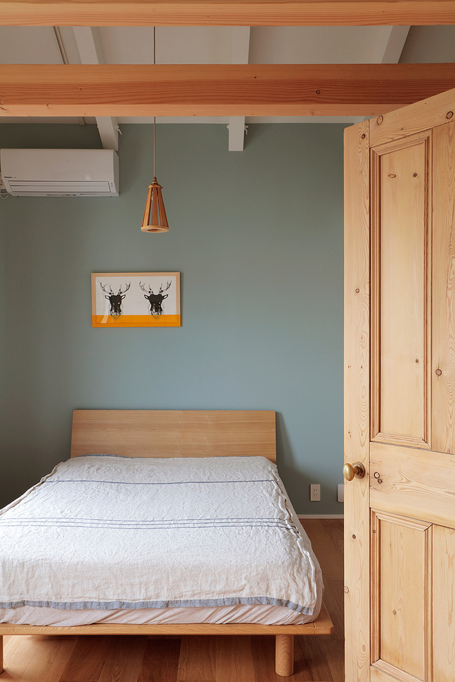 Scandinavian bedroom in Tokyo Suburbs with green walls, medium hardwood floors and brown floor.