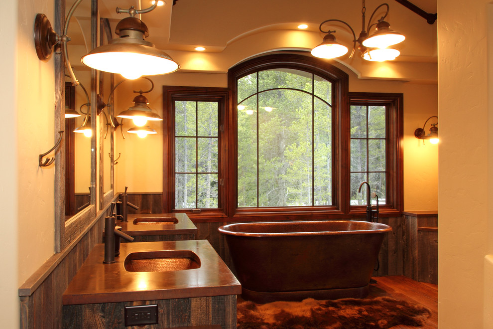 Photo of a large country master bathroom in Denver with an undermount sink, medium wood cabinets, a freestanding tub, beige walls, medium hardwood floors, shaker cabinets and copper benchtops.