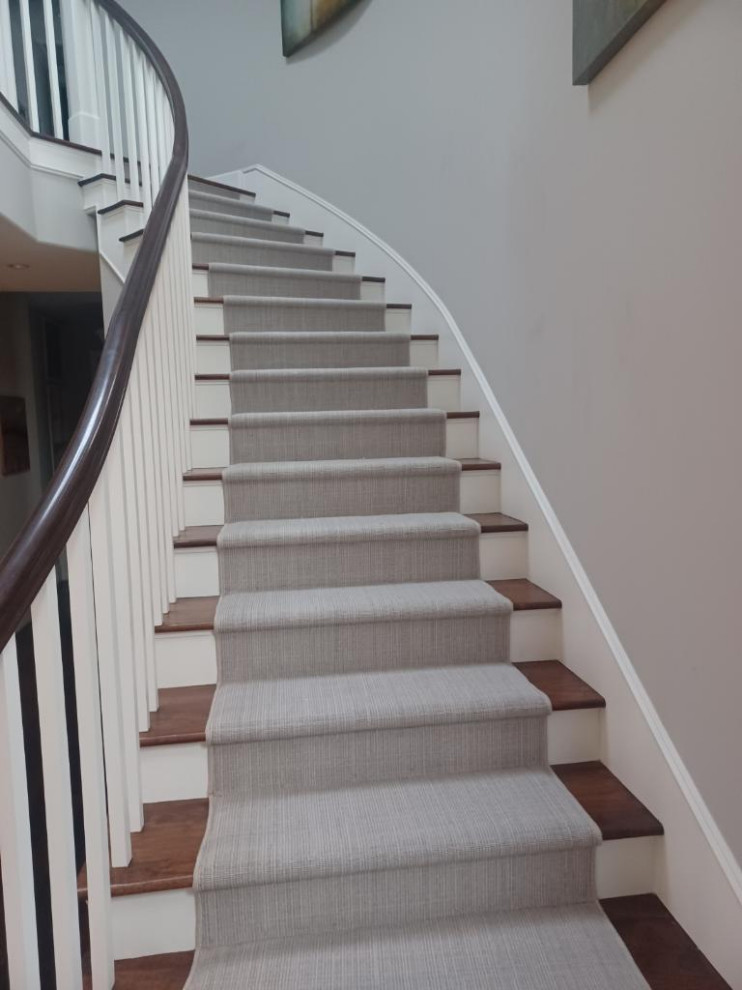Imagen de escalera curva tradicional de tamaño medio con escalones de madera, contrahuellas de madera pintada y barandilla de madera