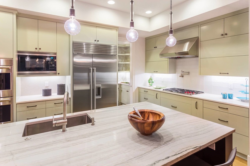 Kitchen - transitional kitchen idea in Miami with a single-bowl sink, flat-panel cabinets, beige cabinets, granite countertops, white backsplash, glass tile backsplash, stainless steel appliances and an island