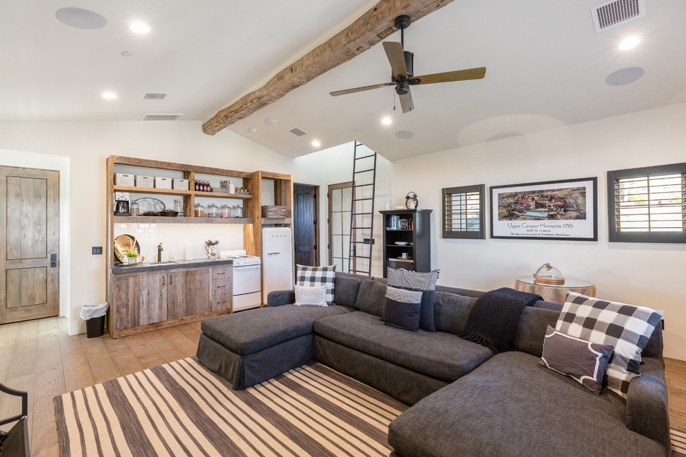 Mediterranean family room in Phoenix with white walls, dark hardwood floors and brown floor.