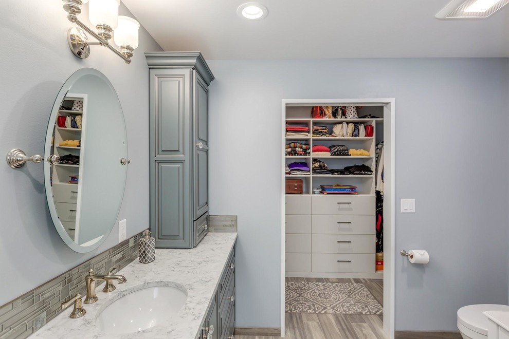 Inspiration for a mid-sized traditional master bathroom in Portland with beaded inset cabinets, grey cabinets, an open shower, a one-piece toilet, white tile, marble, grey walls, porcelain floors, an undermount sink, engineered quartz benchtops, grey floor, a hinged shower door and white benchtops.