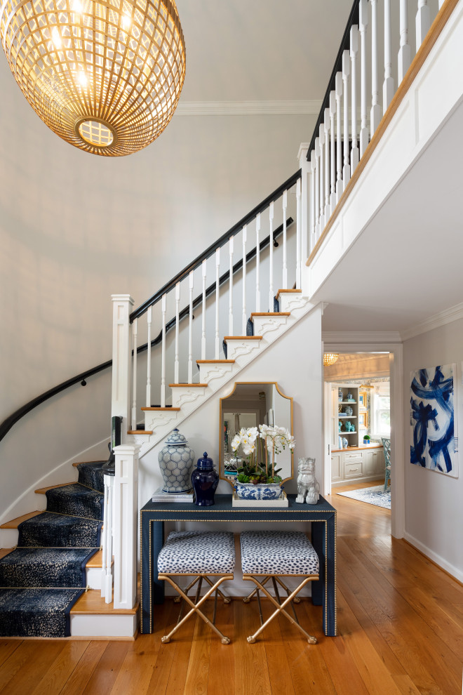 Wooden curved wood railing staircase photo in Philadelphia with painted risers