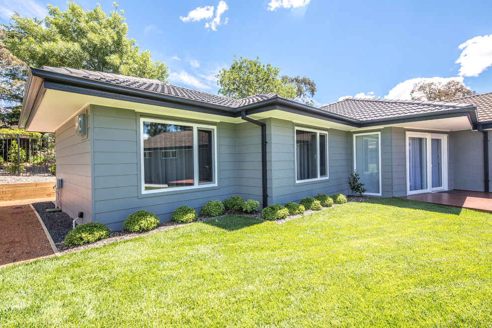 Mid-sized traditional one-storey grey house exterior in Canberra - Queanbeyan with wood siding and a tile roof.