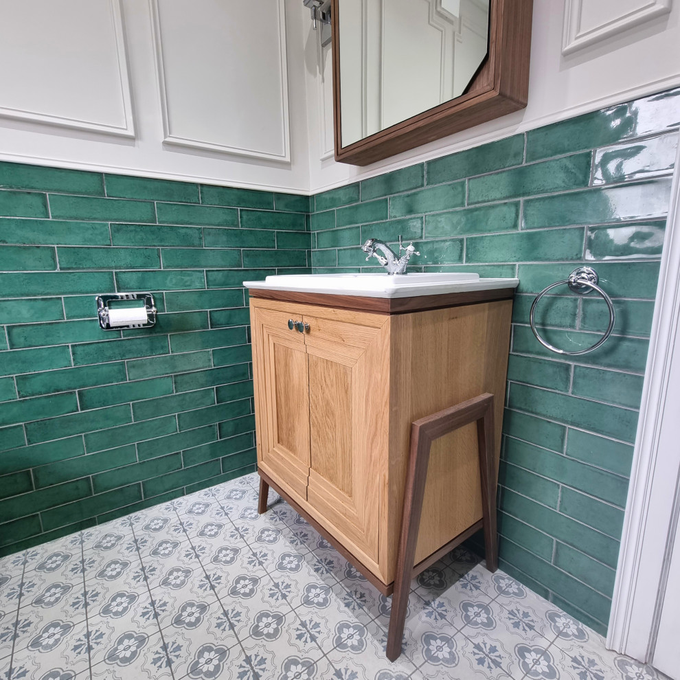 Klassisk inredning av ett badrum, med ett fristående badkar, grön kakel och keramikplattor