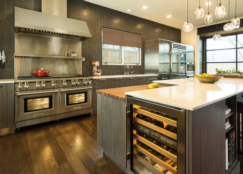 Inspiration for a large transitional l-shaped medium tone wood floor and brown floor open concept kitchen remodel in Philadelphia with an undermount sink, flat-panel cabinets, medium tone wood cabinets, solid surface countertops, brown backsplash, ceramic backsplash, stainless steel appliances, an island and white countertops