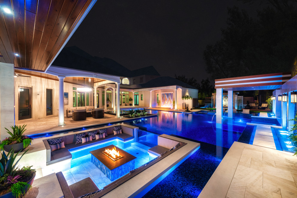 Inspiration for a large contemporary backyard custom-shaped infinity pool in Tampa with with privacy feature and tile.