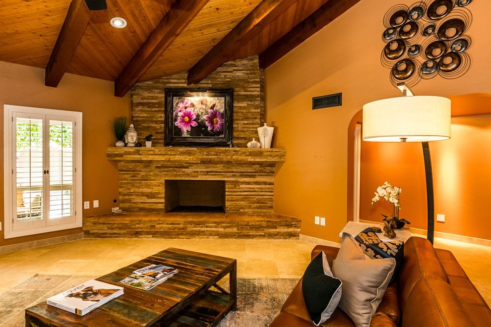 This is an example of a mid-sized country open concept living room in Phoenix with beige walls, travertine floors, a standard fireplace and a tile fireplace surround.