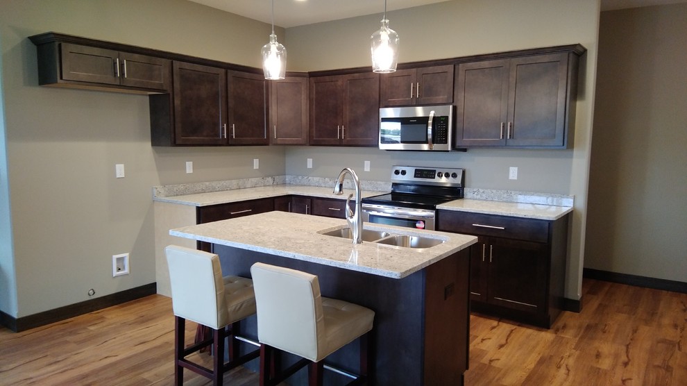 Mid-sized transitional l-shaped vinyl floor and brown floor eat-in kitchen photo in Cedar Rapids with a double-bowl sink, shaker cabinets, gray cabinets, granite countertops, stainless steel appliances and an island