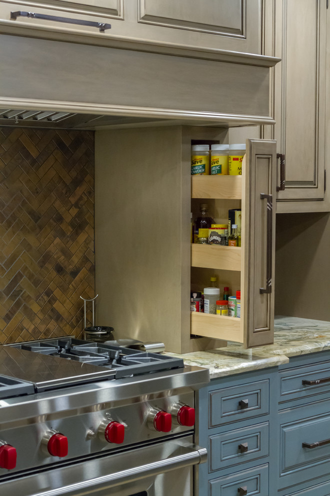 Example of a mountain style kitchen design with stainless steel appliances and an island