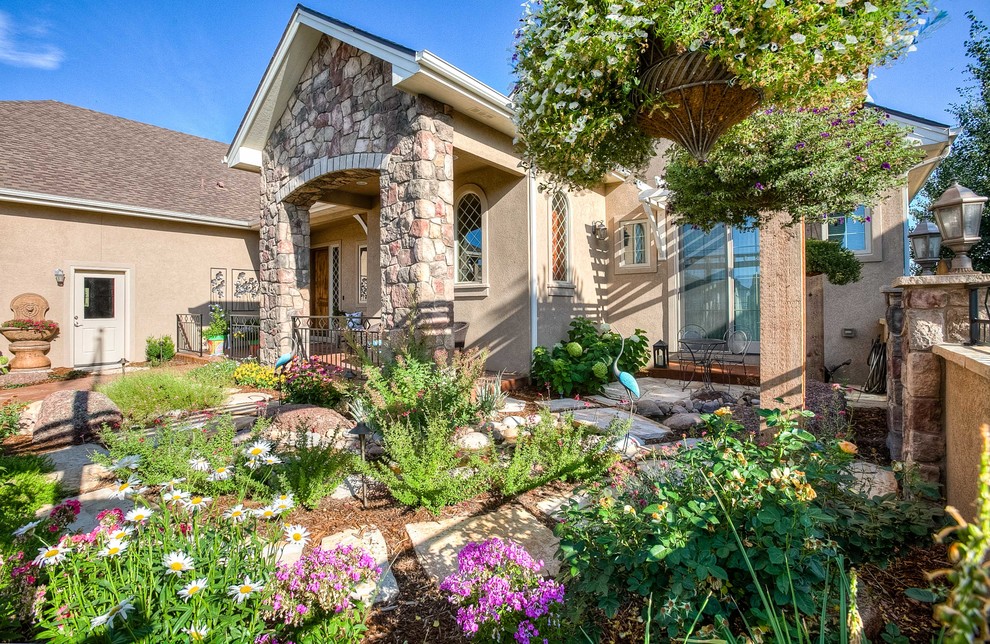 Photo of a mid-sized transitional partial sun front yard stone walkway in Denver.
