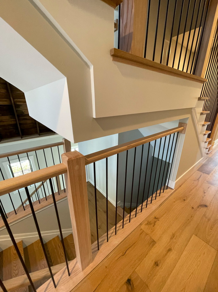 Свежая идея для дизайна: огромная прямая деревянная лестница в стиле неоклассика (современная классика) с деревянными ступенями и перилами из смешанных материалов - отличное фото интерьера