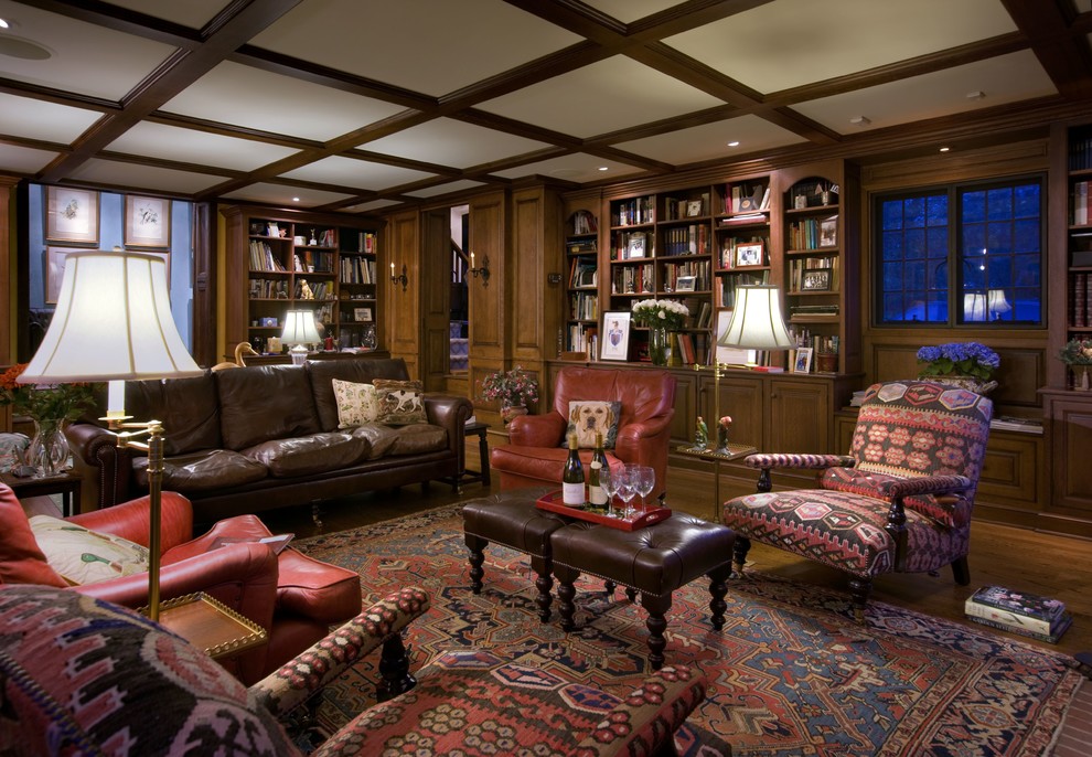 Photo of a large traditional enclosed family room in Newark with a wood fireplace surround, a library, brown walls, dark hardwood floors, a hanging fireplace, a concealed tv and brown floor.