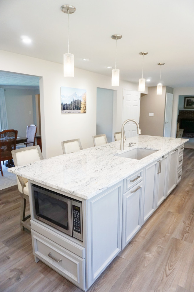 Kitchen - mid-sized transitional kitchen idea with an undermount sink, recessed-panel cabinets, white cabinets, granite countertops, gray backsplash, stainless steel appliances and white countertops