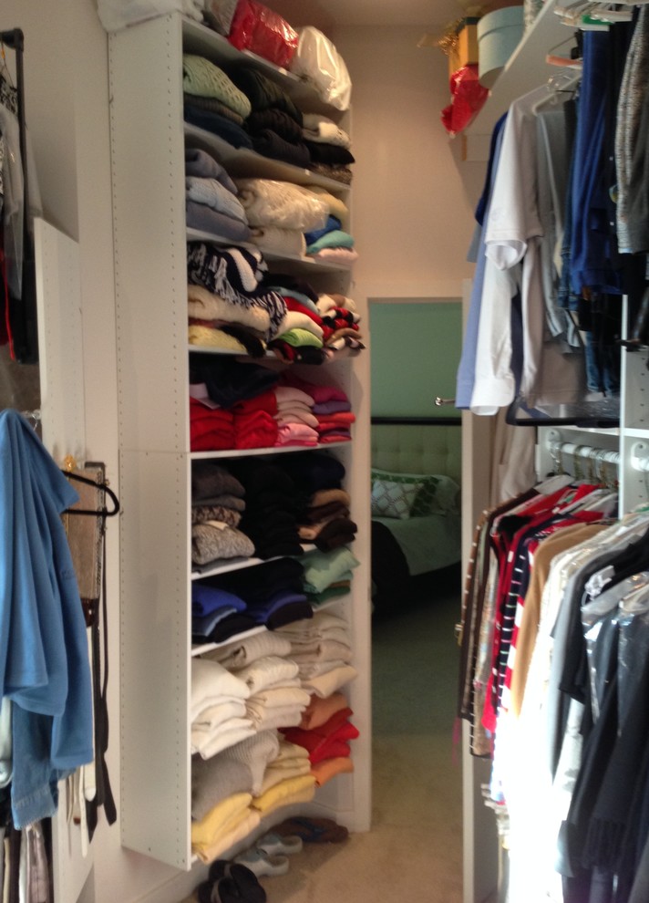 This is an example of a large transitional women's walk-in wardrobe in Philadelphia with white cabinets and carpet.