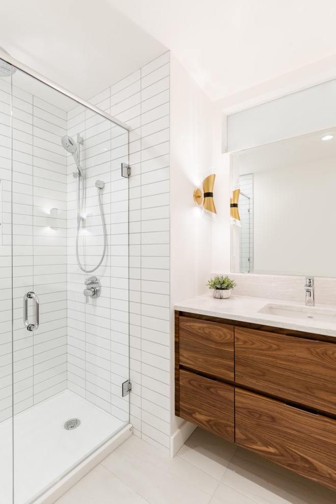 Design ideas for a small midcentury 3/4 bathroom in Vancouver with flat-panel cabinets, medium wood cabinets, an alcove shower, a two-piece toilet, white tile, ceramic tile, white walls, porcelain floors, an undermount sink, engineered quartz benchtops, white floor, a hinged shower door and white benchtops.