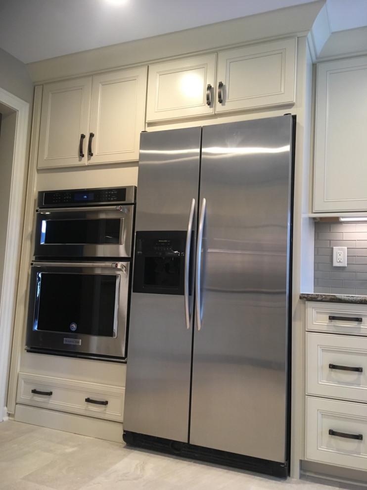 Example of a transitional ceramic tile and gray floor kitchen design with an undermount sink, recessed-panel cabinets, white cabinets, gray backsplash and stainless steel appliances