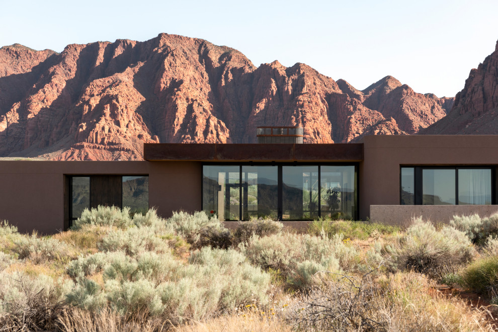 Inspiration pour une façade de maison beige en stuc de plain-pied avec un toit plat et un toit en métal.