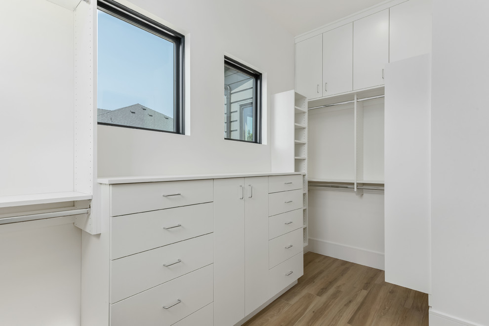 Design ideas for a large contemporary gender-neutral walk-in wardrobe in Salt Lake City with flat-panel cabinets, white cabinets, porcelain floors and beige floor.