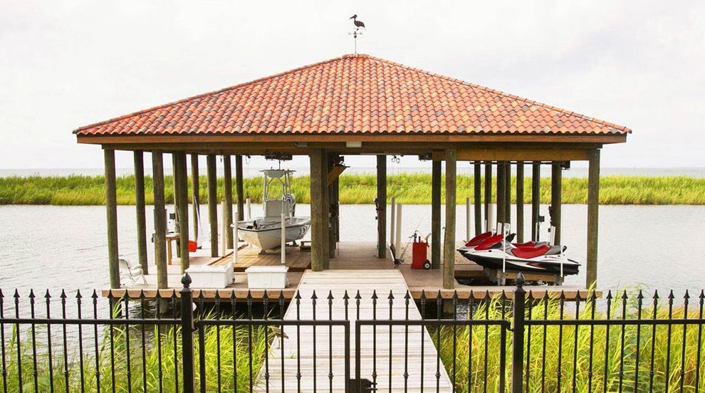 Design ideas for a large traditional backyard deck in New Orleans with with dock.