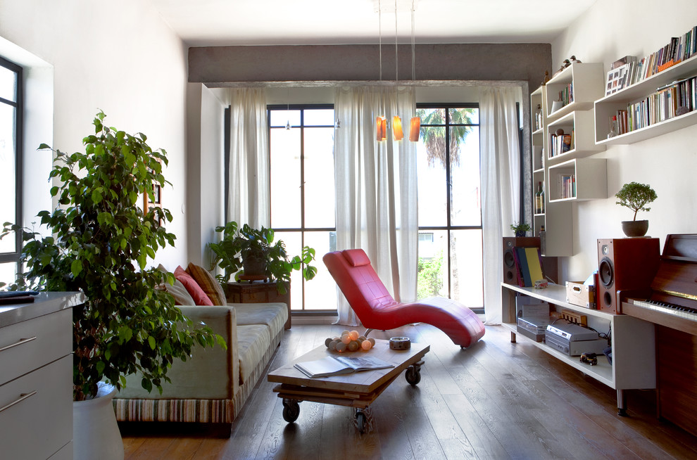 Inspiration for an eclectic enclosed living room with a library and white walls.