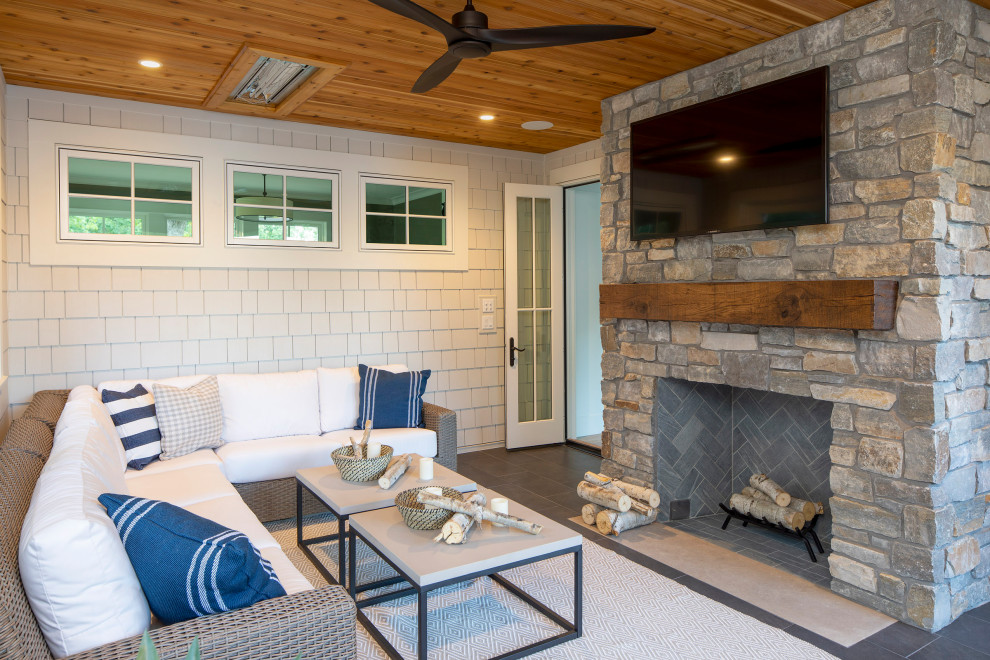 Mid-sized beach style back porch photo in Minneapolis with a fireplace and a roof extension