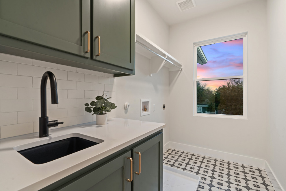 Design ideas for a mid-sized modern single-wall laundry room in Austin with an undermount sink, shaker cabinets, green cabinets, quartz benchtops, white splashback, ceramic splashback, white walls, porcelain floors, a side-by-side washer and dryer and white benchtop.